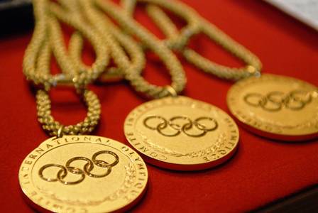 Descrição da imagem: medalhas esportivas sobre pano vermelho